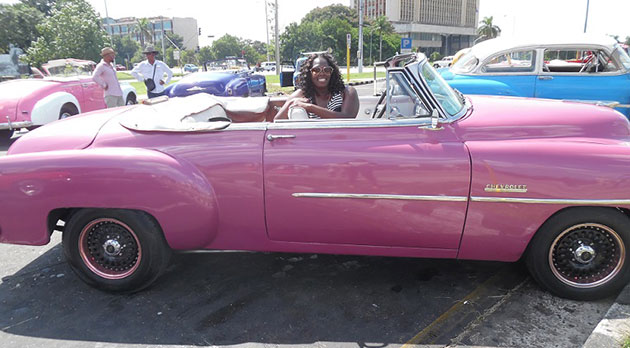 Fallon Wallace sits in a pink convertible car