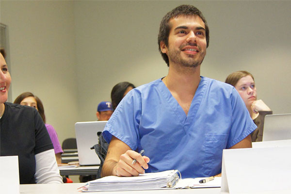 student wearing scrubs in a Healthcare Leadership and Management classroom